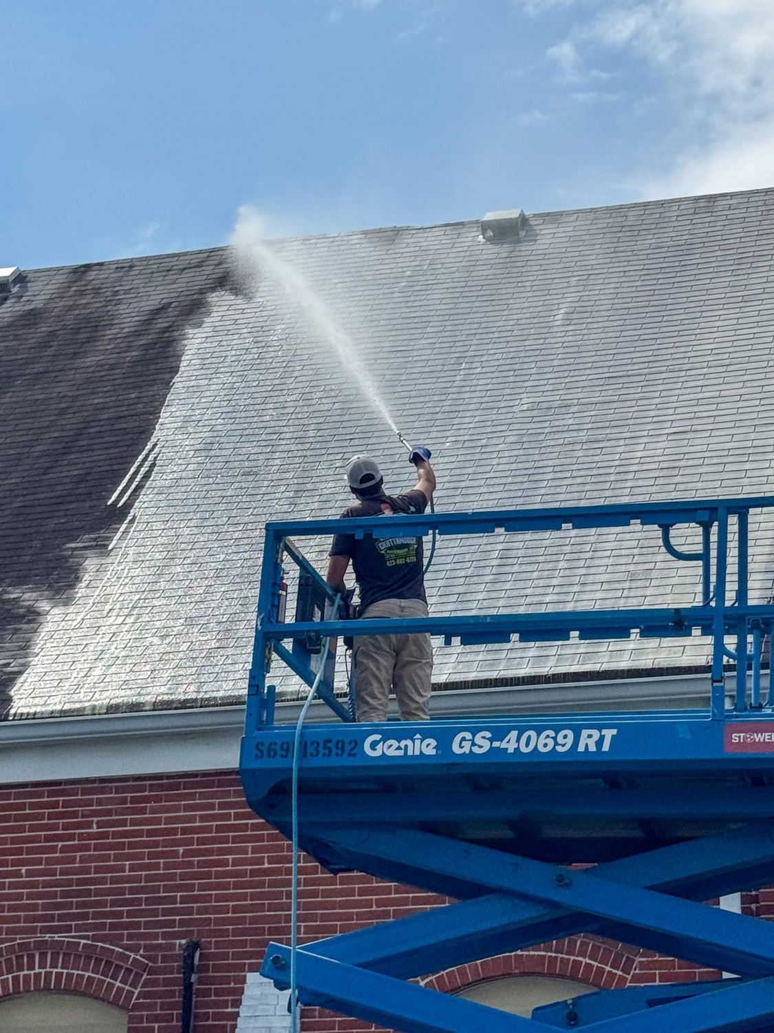 Commercial building being soft washed from a lift