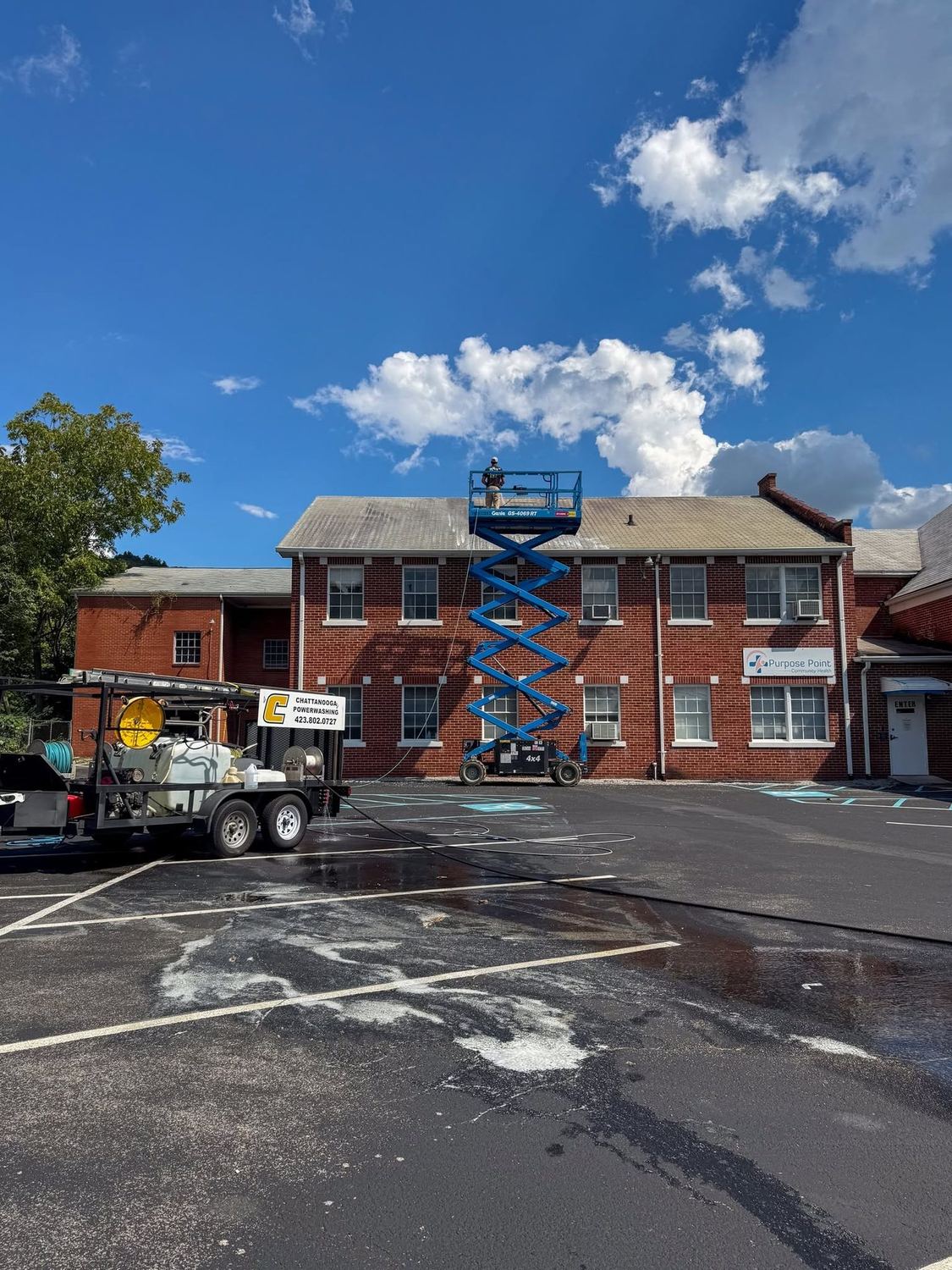 Commercial building being soft washed from a lift