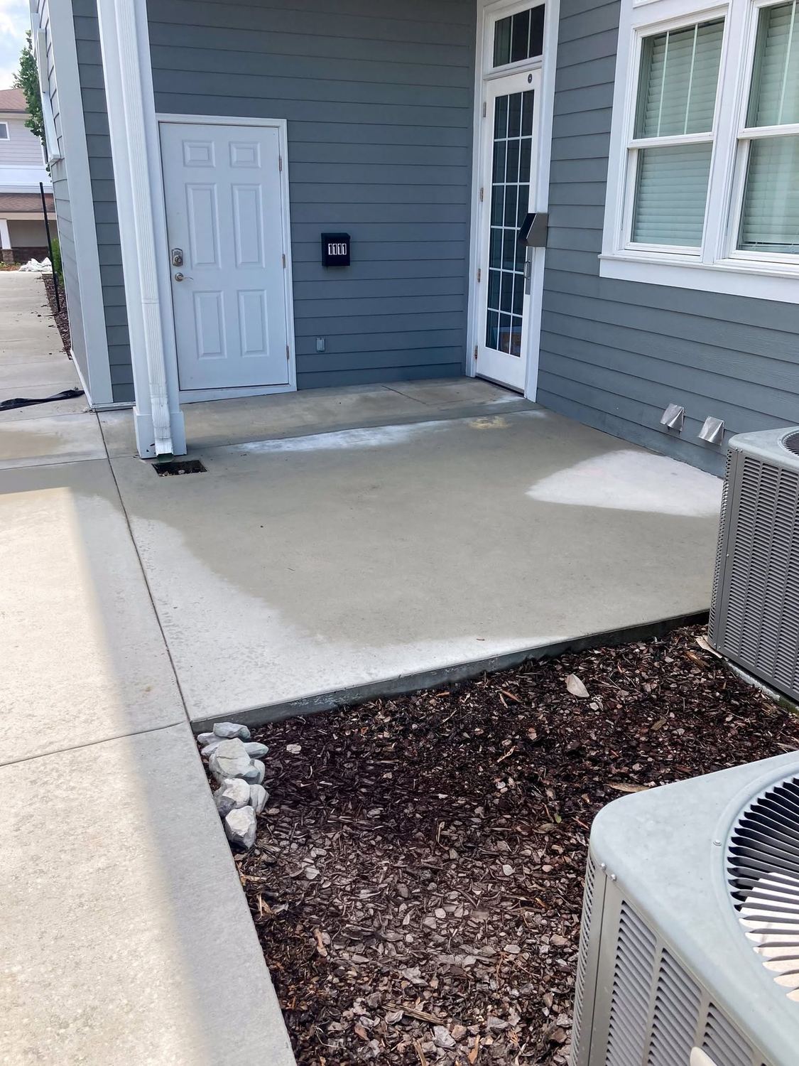 The same concrete patio clean after pressure washing