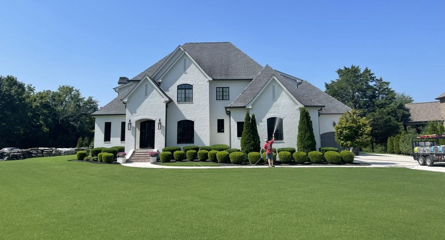 Large home exterior being soft washed